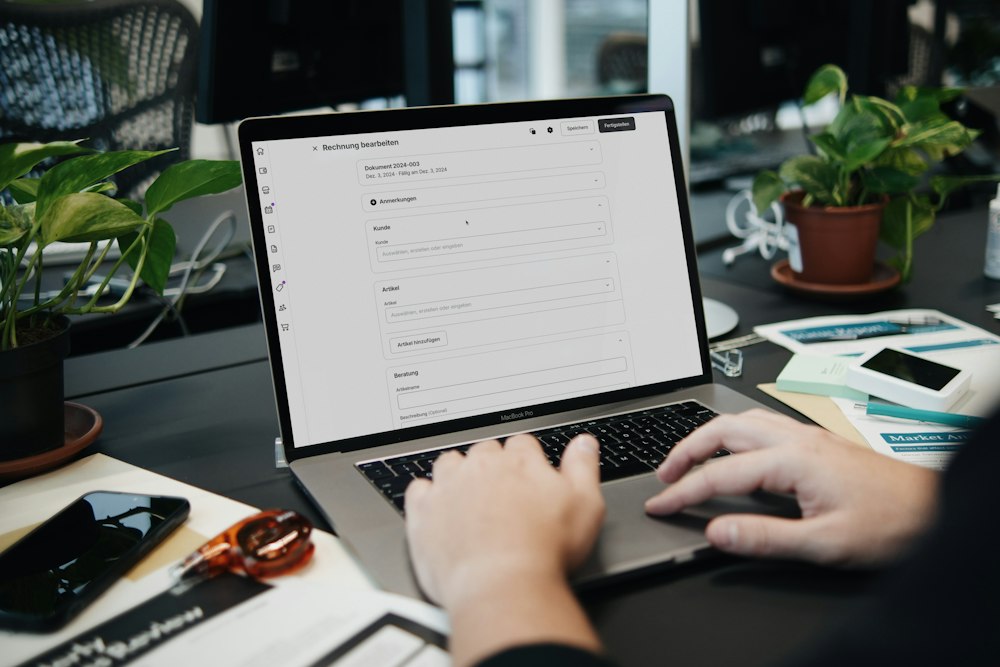 Sfeerfoto van iemand die aan een bureau op een laptop werkt