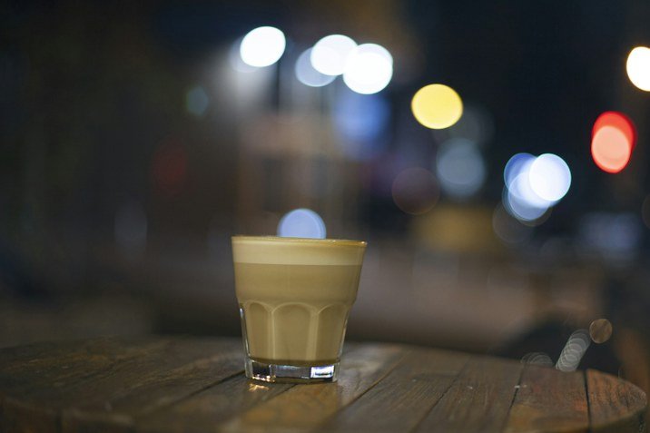 Sfeerfoto van een glas koffie op een houten tafel